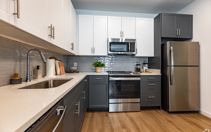 kitchen with grey and white cabinets and stainless steel appliances