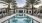 a swimming pool with palm trees and a building in the background at Jefferson Lake Howel Apartments in Casselberry, FL